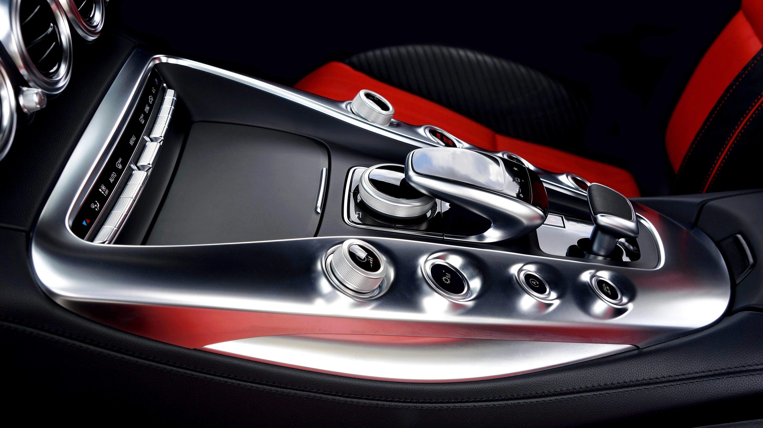 The stylish center console with aluminium elements between black and red sports auto chairs